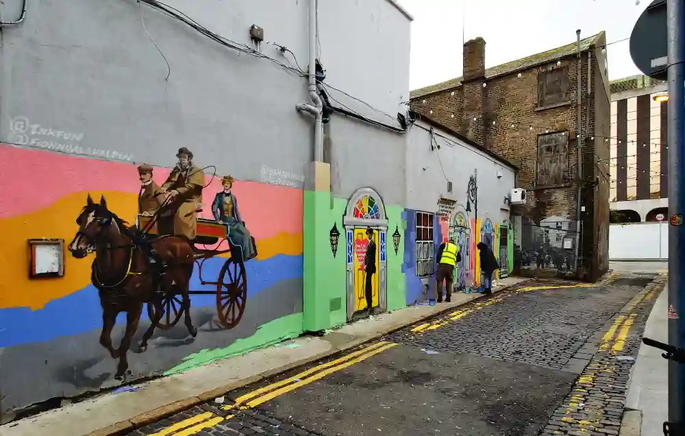 Image: Artists painting a wall with a horse-pulled carriage.