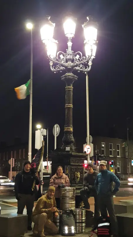 Image: Team with kegs posing in front of a lantern with 5 lights.