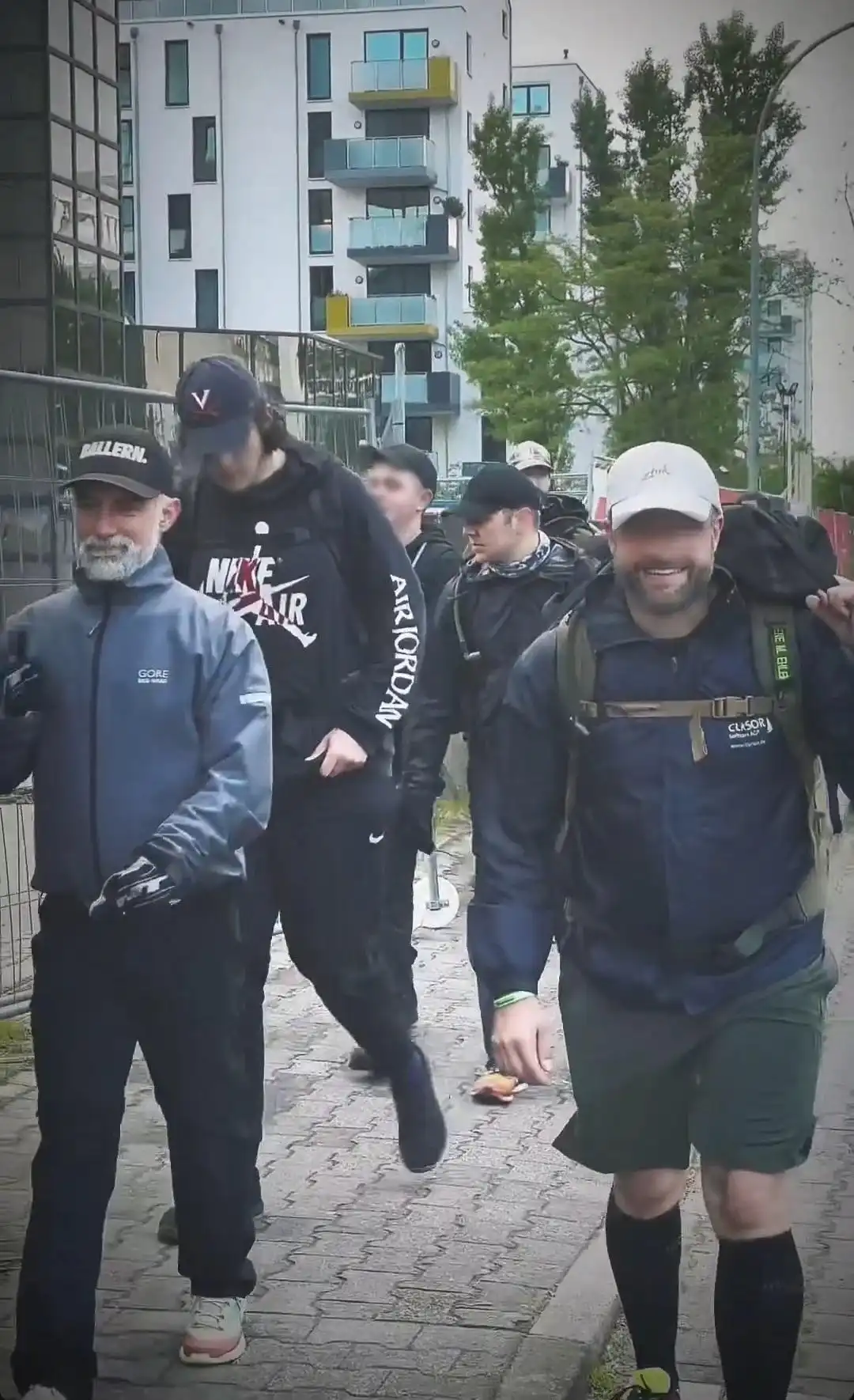 Image: Group movement through the city. Image shot from the front towards the back, capturing several participants rucking