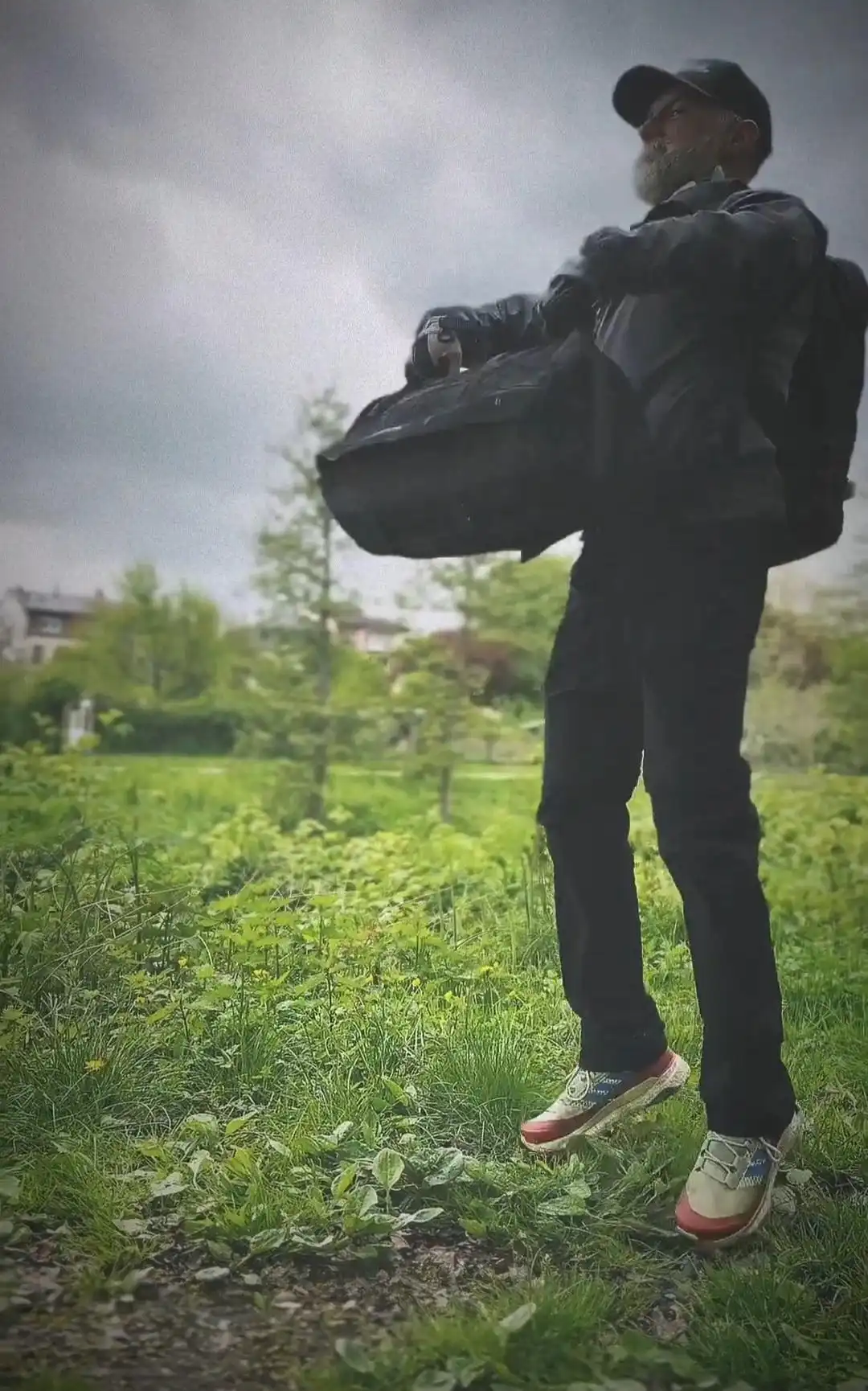 Image: Image of a participant during a group exercise.  The participant is lifting the sandbag in an explosive effort to perform a 