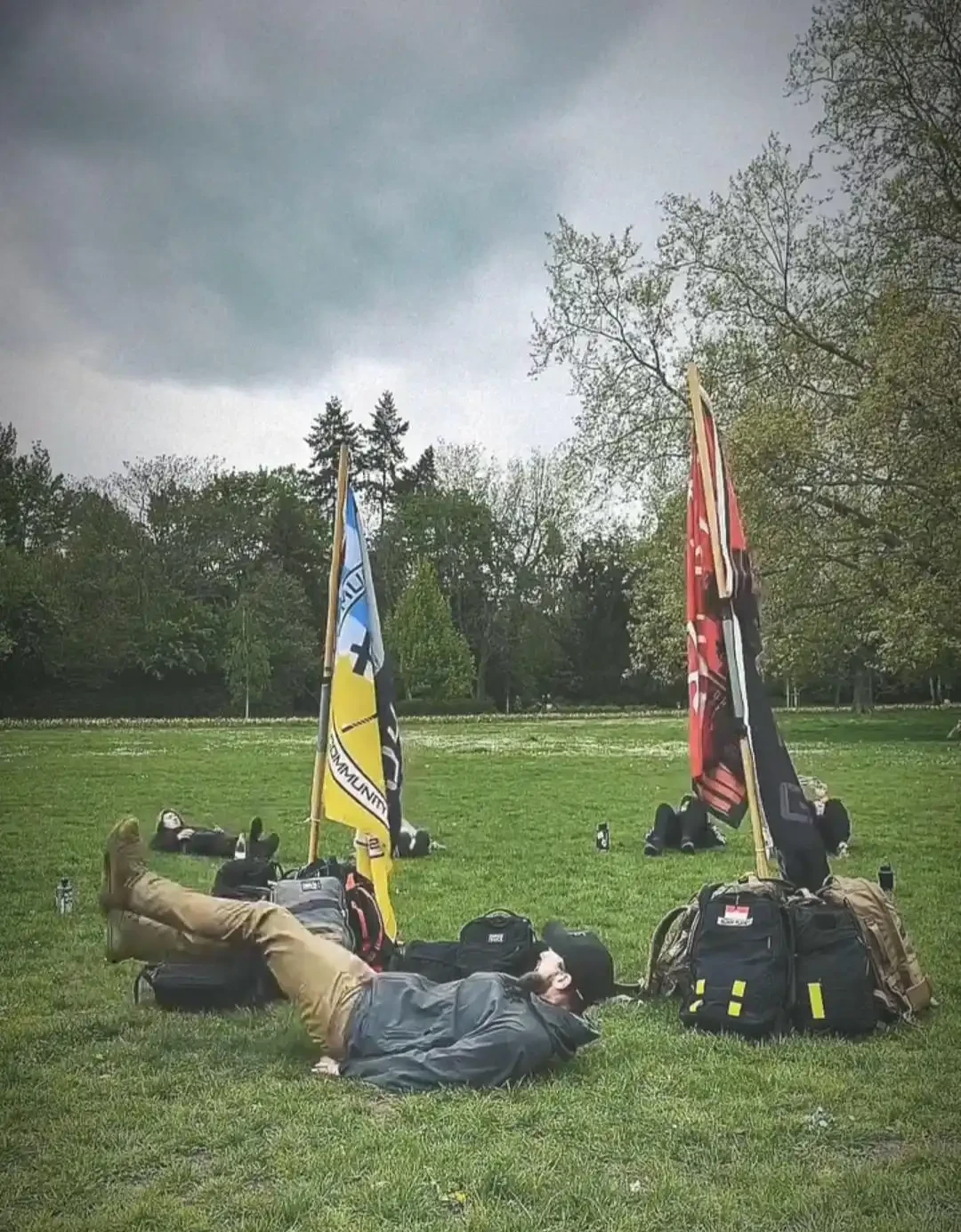 Image: Group-exercise in a park. In the image is a participant leading flutter kicks during a group exercise called 