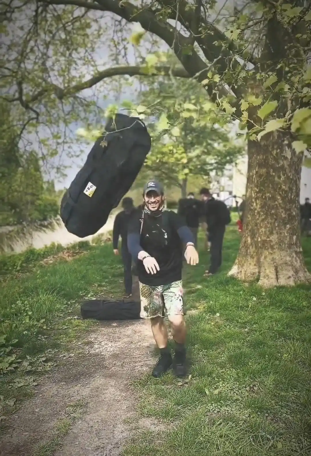 Image: Group-exercise, sandbag workout. Image of sandbag flying in mid air after being thrown forward by a participant