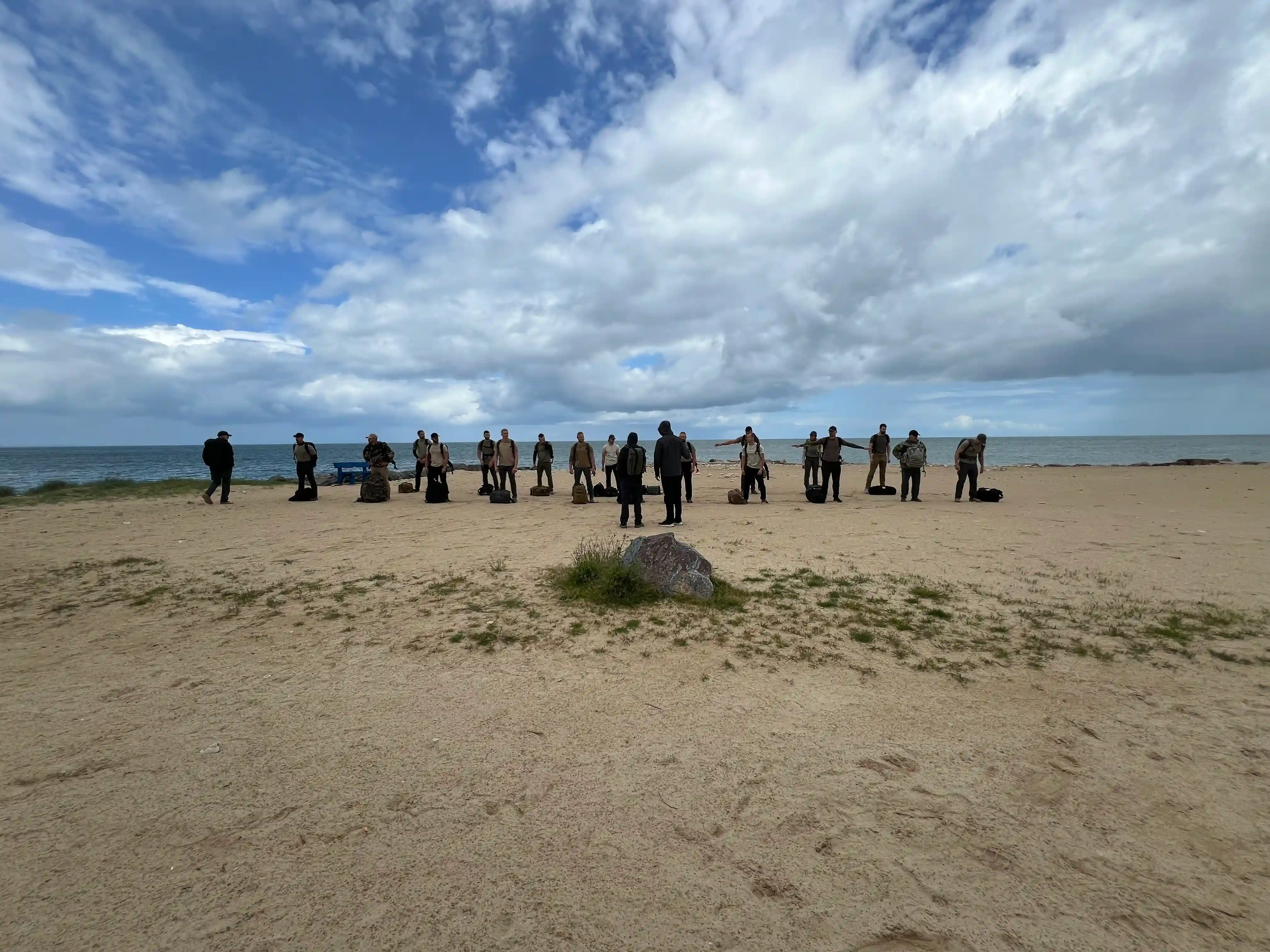 Image: 21 candidates line up in formation on the beach