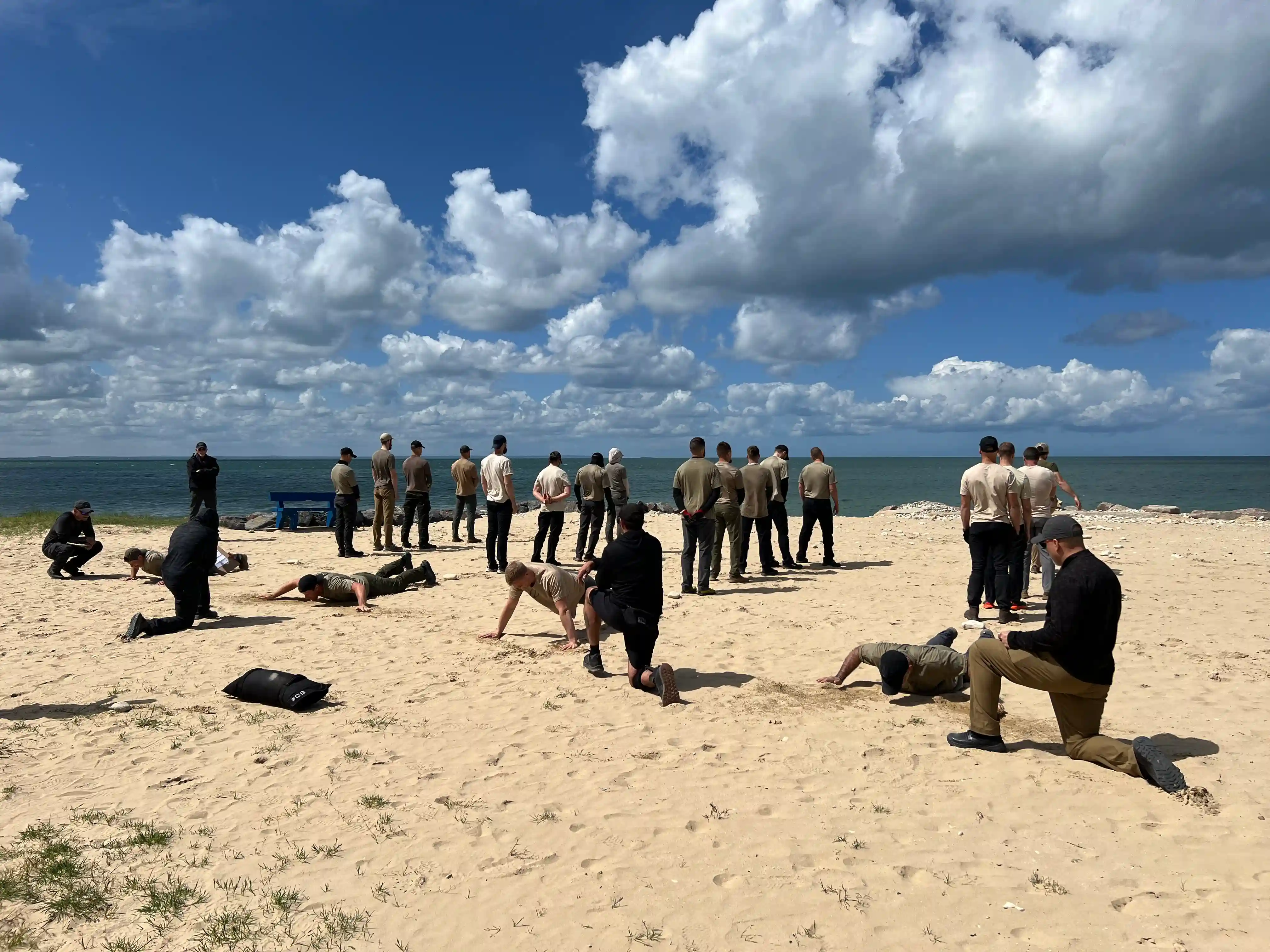Image: Some candidates are being tested on push ups while the rest face the bay